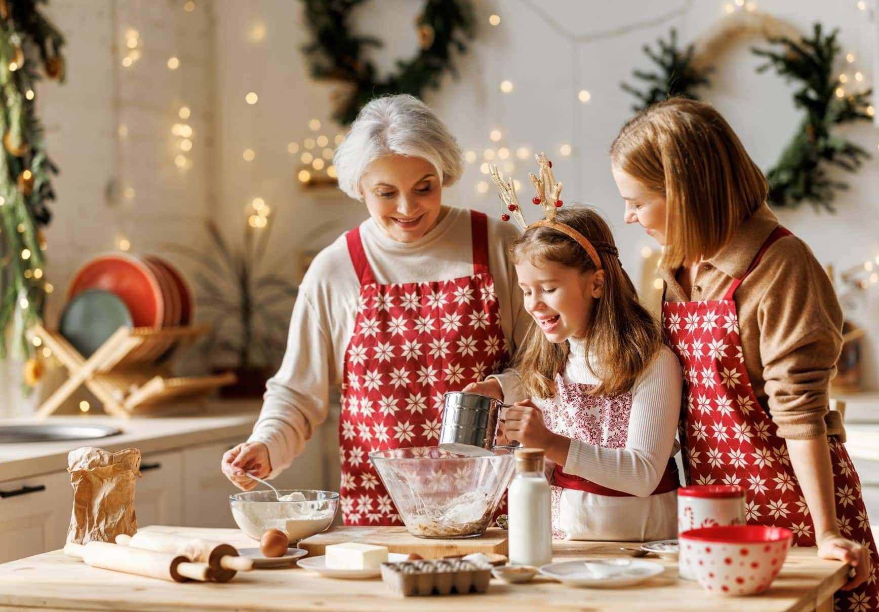 elderly woman, mother, and young daughter making cookies together