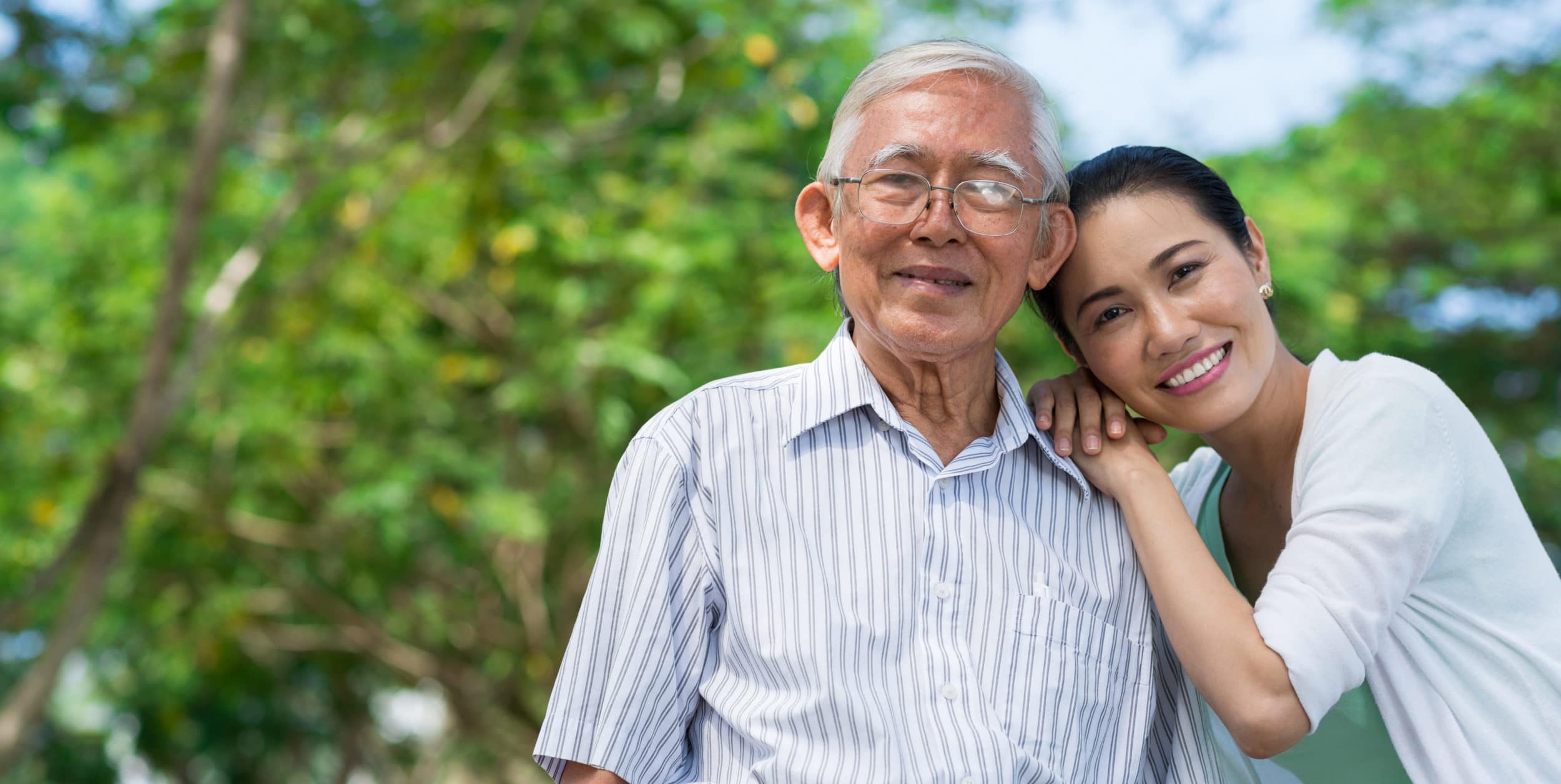 Portrait of happy senior man and his adult daughter leaning on his shoulder