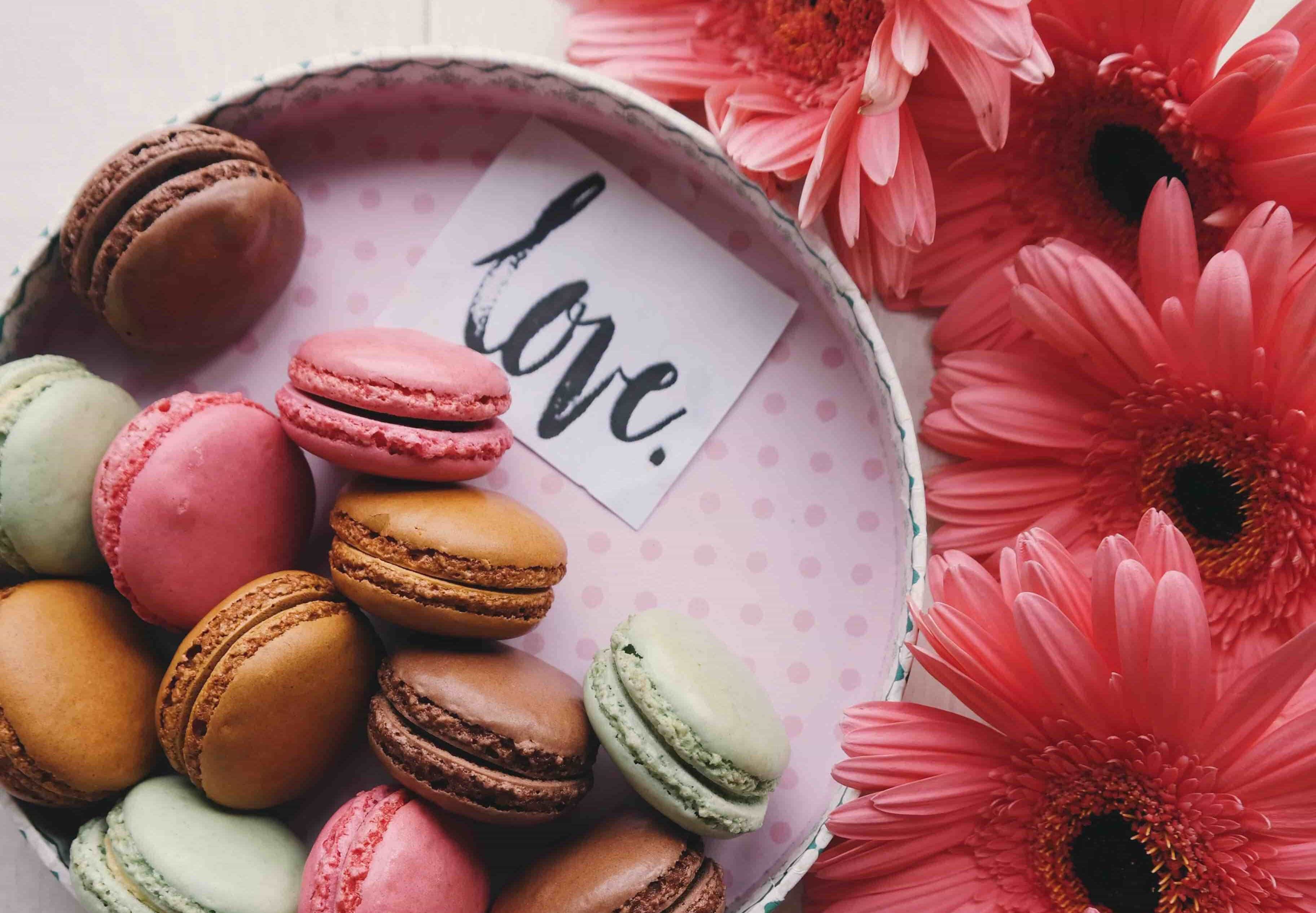 Macaroons and Love Note on a tray next to valentines flowers
