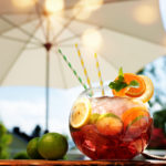 glass of sangria underneath an umbrella outside
