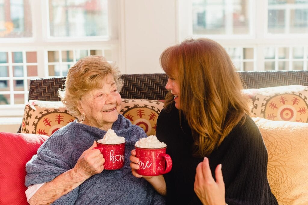 woman resident and woman family member drinking hot cocoa