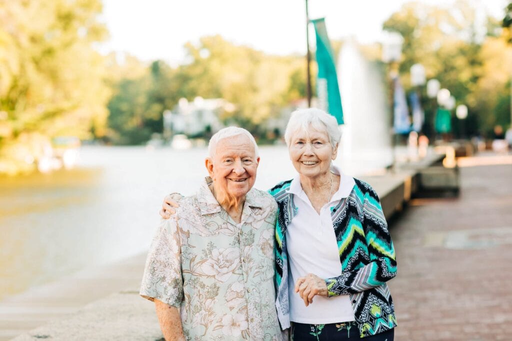 elderly couple walking on sidewalk