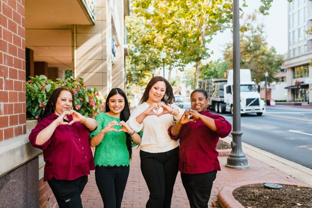 team members showing heart at the camera