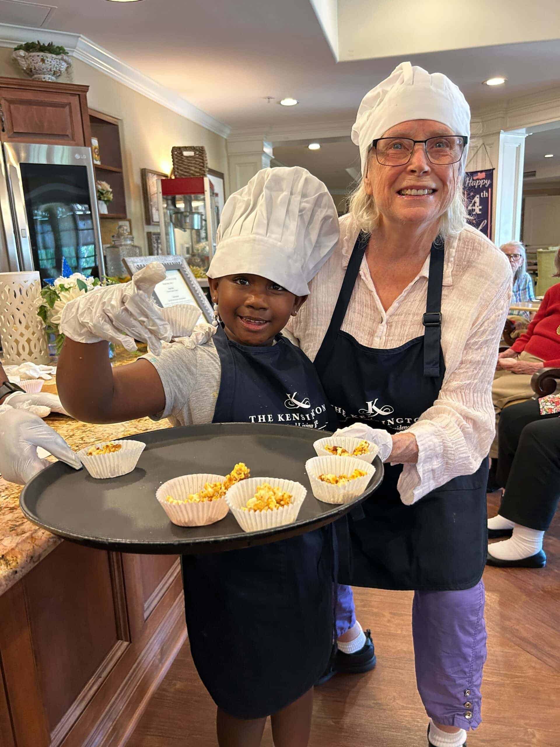 resident and young kid holding tray of treats