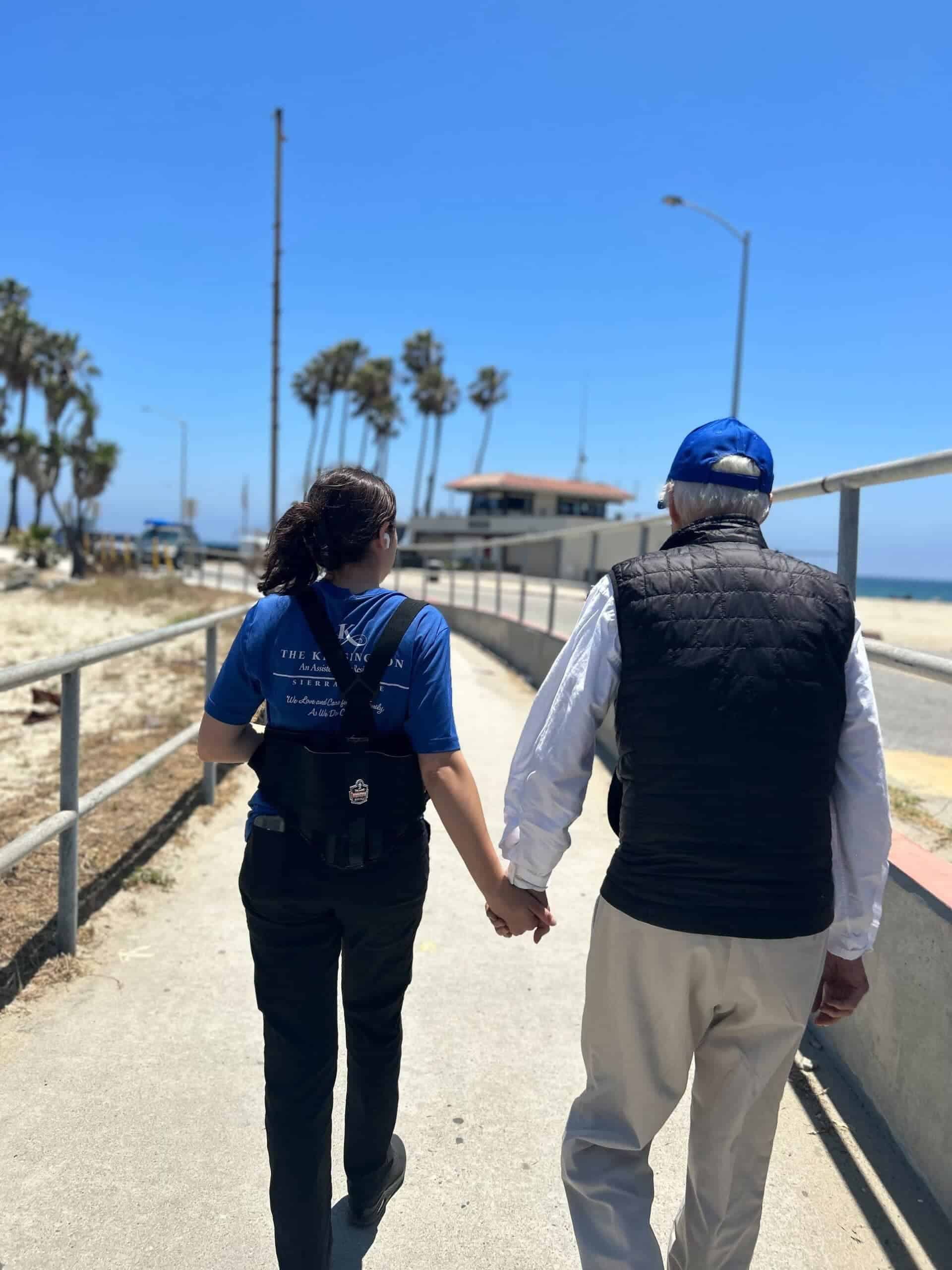 team member and resident walking along beach walkway