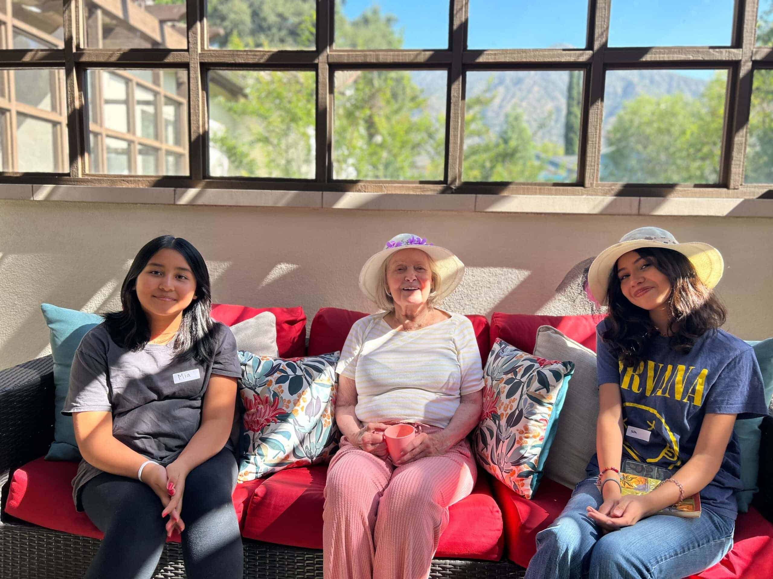 team members sitting with resident in patio area