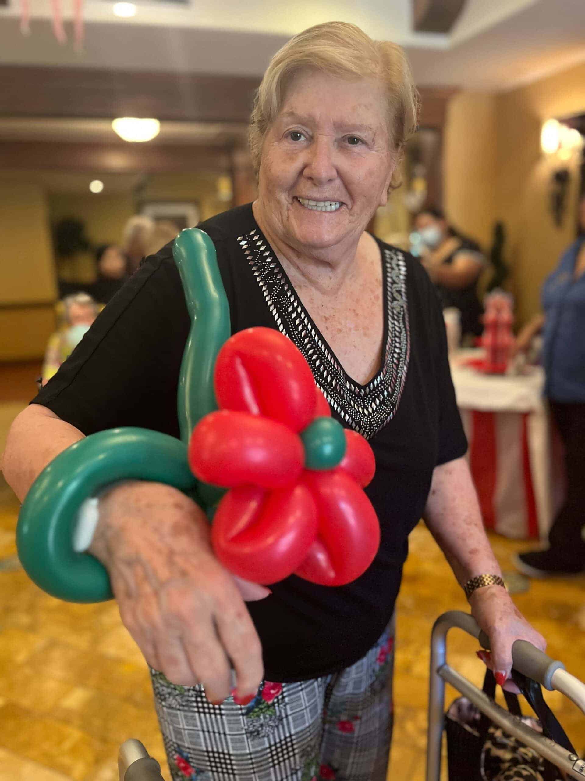 resident with flower made out of balloons