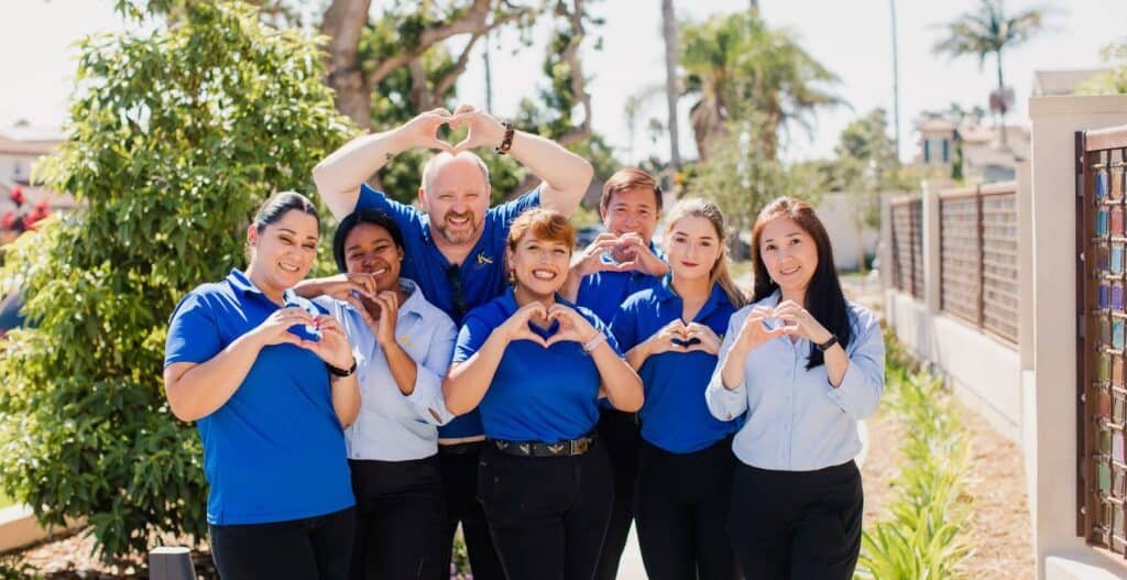 Kensington team members holding up hand heart signs