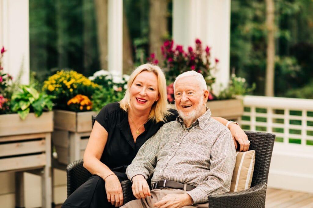 a woman sitting with an older man at a senior living community