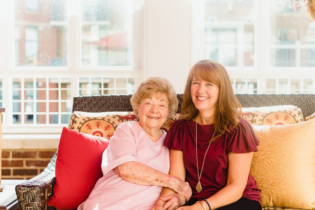 a senior living nurse sitting with a older woman resident